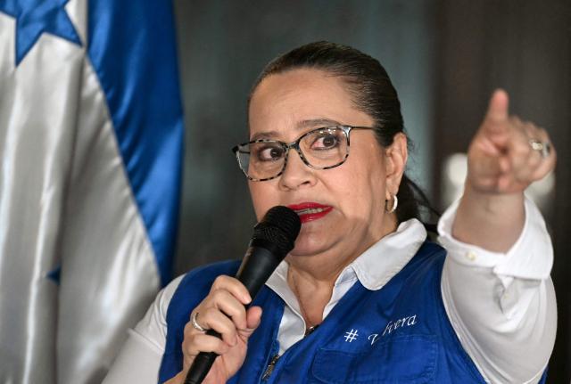 Ana Garcia de Hernandez (C), wife of former Honduras President Juan Orlando Hernandez, talks to the media during a press conference in Tegucigalpa on November 28, 2025. US President Donald Trump said Friday he will pardon Honduran ex-president Juan Orlando Hernandez, who was convicted of drug trafficking and sentenced to 45 years in prison in the US. (Photo by Marvin RECINOS / AFP)