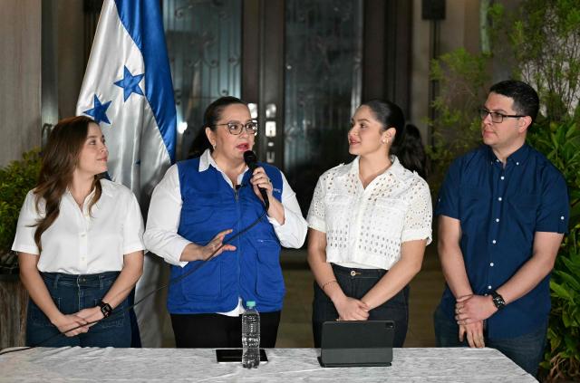 Ana Garcia de Hernandez (2nd L), wife of former Honduras President Juan Orlando Hernandez, talks to the media next to her children during a press conference in Tegucigalpa on November 28, 2025. US President Donald Trump said Friday he will pardon Honduran ex-president Juan Orlando Hernandez, who was convicted of drug trafficking and sentenced to 45 years in prison in the US. (Photo by Marvin RECINOS / AFP)