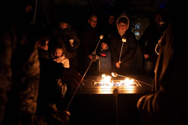 People cook s'mores while they visit the Smithsonian National Zoo during their holiday zoo lights exhibit November 28, 2025, in Washington, DC. (Photo by Brendan Smialowski / AFP)