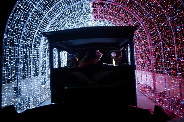 An employee drives a train as people visit the Smithsonian National Zoo during their holiday zoo lights exhibit November 28, 2025, in Washington, DC. (Photo by Brendan Smialowski / AFP)