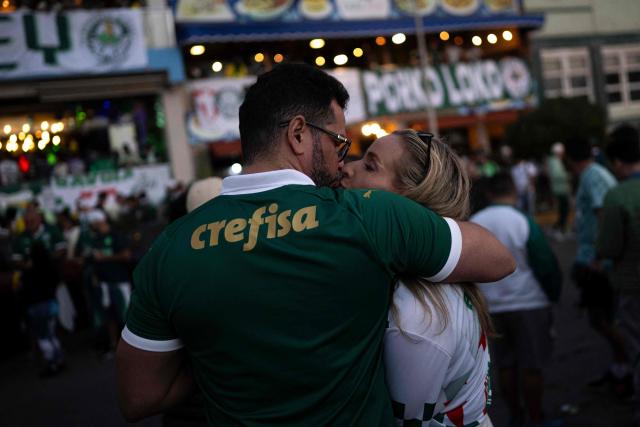 A couple kisses during a gathering of Palmeiras fans on the eve of the all-Brazilian Copa Libertadores final football match between Palmeiras and Flamengo at La Herradura beach in Lima on November 28, 2025. (Photo by Ernesto BENAVIDES / AFP)