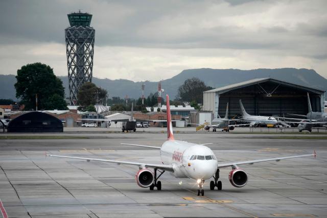 An Avianca plane sit on the tarmac at El Dorado airport in Bogota on November 28, 2025. Colombian airline Avianca reported on Friday "significant" disruptions to its flights due to a required Airbus software update affecting 70 percent of the company's fleet. (Photo by Sergio Yate / AFP)