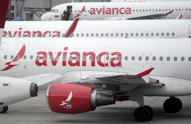 Avianca planes sit on the tarmac at El Dorado airport in Bogota on November 28, 2025. Colombian airline Avianca reported on Friday "significant" disruptions to its flights due to a required Airbus software update affecting 70 percent of the company's fleet. (Photo by Sergio Yate / AFP)