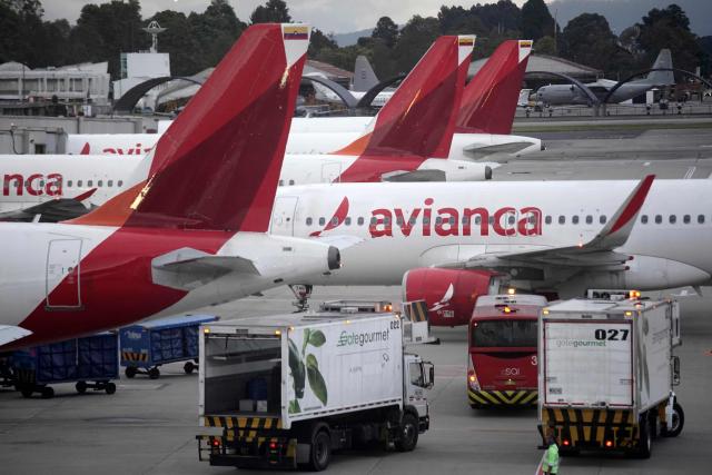Avianca planes sit on the tarmac at El Dorado airport in Bogota on November 28, 2025. Colombian airline Avianca reported on Friday "significant" disruptions to its flights due to a required Airbus software update affecting 70 percent of the company's fleet. (Photo by Sergio Yate / AFP)