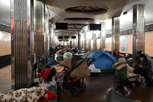 People take shelter at a metro station during an air attack in Kyiv on November 29, 2025, amid the Russian invasion of Ukraine. Loud explosions were heard in the Ukrainian capital Kyiv early on November 29, 2025, the mayor and AFP journalists said. (Photo by Sergei GAPON / AFP)