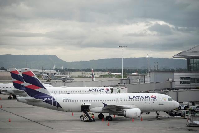 Latam Airlines planes sit on the tarmac at El Dorado airport in Bogota on November 28, 2025. The International Air Transport Association (IATA) urged Venezuela on November 27 to "reconsider" the revocation of concessions for six airlines that canceled their flights following a security alert issued by the United States. The measure affected Spain's Iberia, Portugal's TAP, Colombia's Avianca, the Colombian subsidiary of Chilean-Brazilian Latam, Brazil's GOL and Turkey's Turkish Airlines, which had suspended their connections with Venezuela after Washington issued an alert over military activity in the southern Caribbean. (Photo by Sergio Yate / AFP)