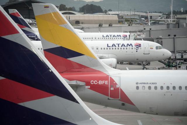 Latam Airlines planes sit on the tarmac at El Dorado airport in Bogota on November 28, 2025. The International Air Transport Association (IATA) urged Venezuela on November 27 to "reconsider" the revocation of concessions for six airlines that canceled their flights following a security alert issued by the United States. The measure affected Spain's Iberia, Portugal's TAP, Colombia's Avianca, the Colombian subsidiary of Chilean-Brazilian Latam, Brazil's GOL and Turkey's Turkish Airlines, which had suspended their connections with Venezuela after Washington issued an alert over military activity in the southern Caribbean. (Photo by Sergio Yate / AFP)