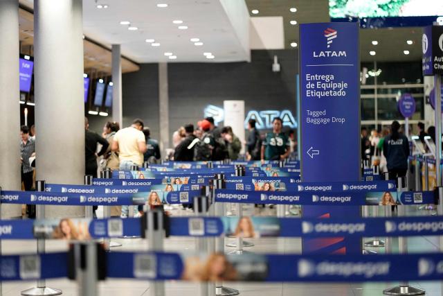 Passengers check in at Latam Airlines counters at El Dorado airport in Bogota on November 28, 2025. The International Air Transport Association (IATA) urged Venezuela on November 27 to "reconsider" the revocation of concessions for six airlines that canceled their flights following a security alert issued by the United States. The measure affected Spain's Iberia, Portugal's TAP, Colombia's Avianca, the Colombian subsidiary of Chilean-Brazilian Latam, Brazil's GOL and Turkey's Turkish Airlines, which had suspended their connections with Venezuela after Washington issued an alert over military activity in the southern Caribbean. (Photo by Sergio Yate / AFP)
