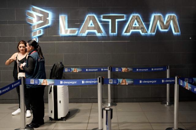 The Latam Airlines logo is pictured at El Dorado airport in Bogota on November 28, 2025. The International Air Transport Association (IATA) urged Venezuela on November 27 to "reconsider" the revocation of concessions for six airlines that canceled their flights following a security alert issued by the United States. The measure affected Spain's Iberia, Portugal's TAP, Colombia's Avianca, the Colombian subsidiary of Chilean-Brazilian Latam, Brazil's GOL and Turkey's Turkish Airlines, which had suspended their connections with Venezuela after Washington issued an alert over military activity in the southern Caribbean. (Photo by Sergio Yate / AFP)
