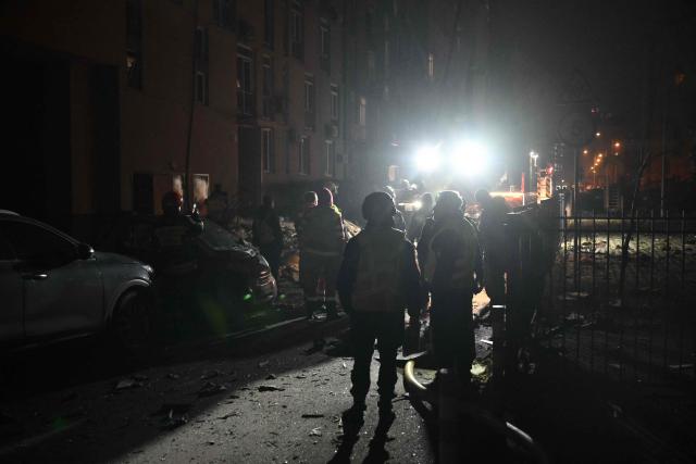 Rescuers work outside a damaged residential building following a drone attack to Kyiv on November 29, 2025, amid Russian invasion in Ukraine. A Russian drone attack targeted the Ukrainian capital in the early hours of November 29, 2025, wounding seven people, authorities in Kyiv said. (Photo by Genya SAVILOV / AFP)