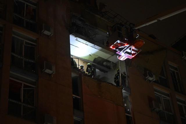 Rescuers work in a damaged residential building following a drone attack to Kyiv on November 29, 2025, amid Russian invasion in Ukraine. A Russian drone attack targeted the Ukrainian capital in the early hours of November 29, 2025, wounding seven people, authorities in Kyiv said. (Photo by Genya SAVILOV / AFP)