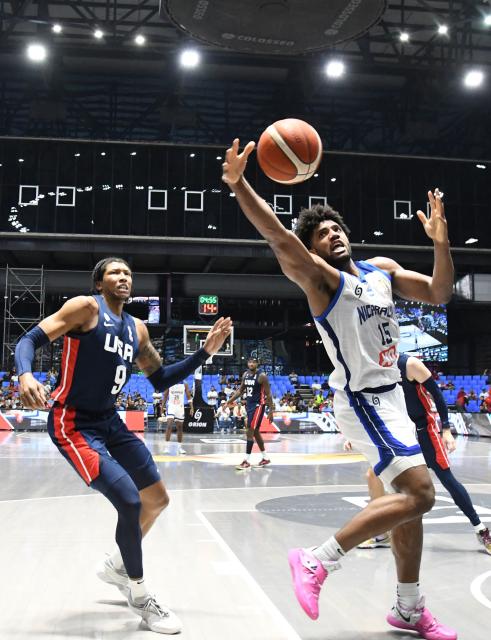 Nicaragua's Norchad Omier (R) controls the ball past USA's MarJon Beauchamp during the FIBA Basketball World Cup 2027 Americas qualifiers Group A match between Nicaragua and USA at the Polideportivo Alexis Arguello stadium in Managua on November 28, 2025. (Photo by AFP)