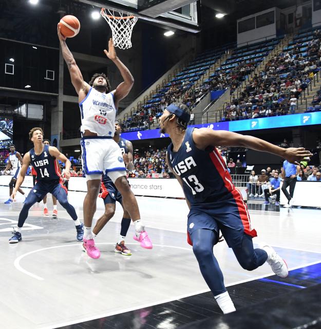 Nicaragua's Norchad Omier heads to the basket past USA's Nate Hinton (R) and Kessier Edwards (L) during the FIBA Basketball World Cup 2027 Americas qualifiers Group A match between Nicaragua and USA at the Polideportivo Alexis Arguello stadium in Managua on November 28, 2025. (Photo by AFP)