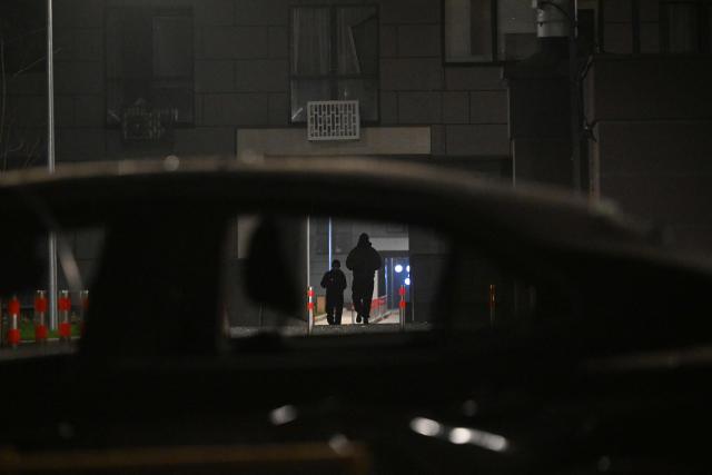 Local residents walk in the courtyard of a damaged residential building following a drone attack in Kyiv on November 29, 2025, amid the Russian invasion in Ukraine. A Russian drone attack targeted the Ukrainian capital in the early hours of November 29, 2025, wounding seven people, authorities in Kyiv said. (Photo by Sergei GAPON / AFP)