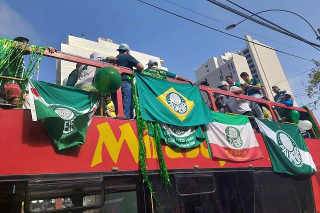 Palmeiras fans cheer for their team while riding a tour bus on the eve of the all-Brazilian Copa Libertadores final football match between Palmeiras and Flamengo in Lima on November 28, 2025. A Palmeiras fan who had traveled to Lima to watch the 2025 Copa Libertadores final against Flamengo died on Friday in a traffic accident, Peruvian police reported. The accident occurred in the afternoon on the ring road along Lima’s bay, aboard a tour bus packed with euphoric Palmeiras supporters. (Photo by Carlos MANDUJANO / AFP)