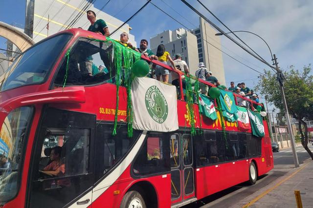 Palmeiras fans cheer for their team while riding a tour bus on the eve of the all-Brazilian Copa Libertadores final football match between Palmeiras and Flamengo in Lima on November 28, 2025. A Palmeiras fan who had traveled to Lima to watch the 2025 Copa Libertadores final against Flamengo died on Friday in a traffic accident, Peruvian police reported. The accident occurred in the afternoon on the ring road along Lima’s bay, aboard a tour bus packed with euphoric Palmeiras supporters. (Photo by Carlos MANDUJANO / AFP)