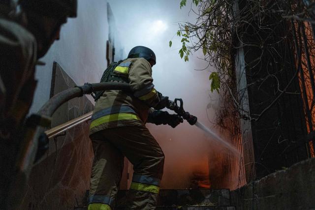 Firefighters put out a fire in a damaged private house following a drone attack to Kyiv on November 29, 2025, amid the Russian invasion in Ukraine. A Russian drone attack targeted the Ukrainian capital in the early hours of November 29, killing one person and wounding seven, authorities in Kyiv said. (Photo by Anton SHTUKA / AFP)