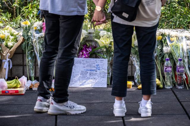 Flowers and messages are seen outside the Wang Fuk Court in the aftermath of the deadly November 26 fire in Hong Kong's Tai Po district on November 29, 2025. An outpouring of grief was set to sweep Hong Kong on November 29 as an official, three-day mourning period began with a moment of silence for the 128 people killed in one of the city's deadliest fires. (Photo by Philip FONG / AFP)