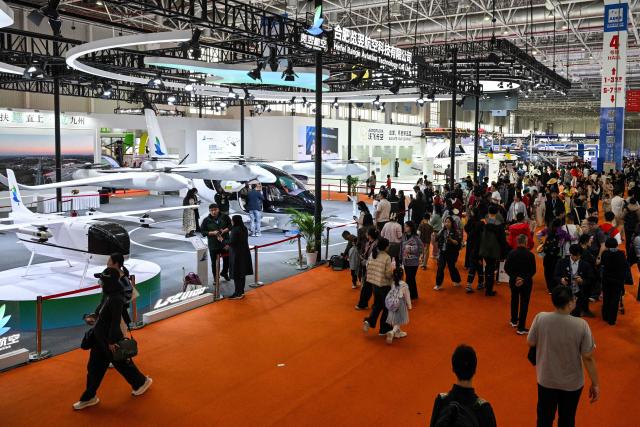 Visitors attend he Aero Asia 2025 in Zhuhai, in southern China's Guangdong province on November 29, 2025. Aero Asia 2025 is an international aviation and aerospace exhibition that runs between November 27 and 30. (Photo by Hector RETAMAL / AFP)