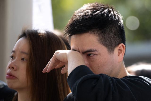 People gather to offer flowers outside the Wang Fuk Court in the aftermath of the deadly November 26 fire in Hong Kong's Tai Po district on November 29, 2025. An outpouring of grief was set to sweep Hong Kong on November 29 as an official, three-day mourning period began with a moment of silence for the 128 people killed in one of the city's deadliest fires. (Photo by Philip FONG / AFP)