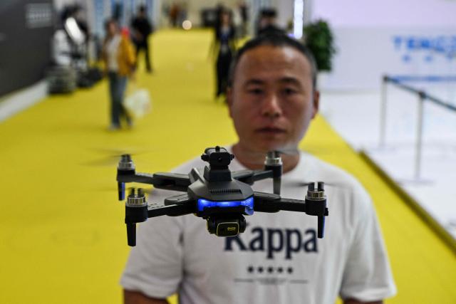 A vendor flies a drone during the Aero Asia 2025 in Zhuhai, in southern China's Guangdong province on November 29, 2025. Aero Asia 2025 is an international aviation and aerospace exhibition that runs between November 27 and 30. (Photo by Hector RETAMAL / AFP)