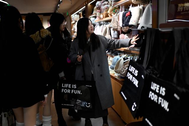 A woman visits a store in Beijing on November 29, 2025. (Photo by WANG Zhao / AFP)