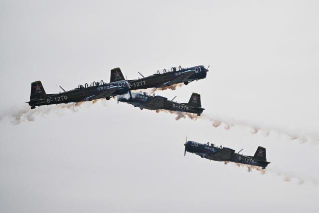The Chinese Red Star Aerobatic team performs during the Aero Asia 2025 in Zhuhai, in southern China's Guangdong province on November 29, 2025. Aero Asia 2025 is an international aviation and aerospace exhibition that runs between November 27 and 30. (Photo by Hector RETAMAL / AFP)