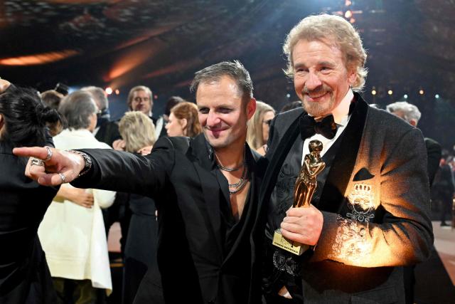 German host and entertainer Thomas Gottschalk (R) holds his trophy as he poses with Austrian actor Philipp Hochmair during the award ceremony of the Kurier Romy Gala in Kitzbühel, Austria on November 28, 2025. (Photo by BARBARA GINDL / APA / AFP) / Austria OUT