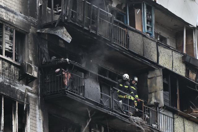 Ukrainian rescuers work in a damaged residential building following a drone attack in Kyiv on November 29, 2025, amid the Russian invasion in Ukraine. A Russian drone attack targeted the Ukrainian capital in the early hours of November 29, 2025, killing one person and wounding seven, authorities in Kyiv said. (Photo by Genya SAVILOV / AFP)
