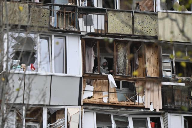 A local resident inspects a damaged balcony in a residential building following a drone attack in Kyiv on November 29, 2025, amid the Russian invasion in Ukraine. A Russian drone attack targeted the Ukrainian capital in the early hours of November 29, 2025, killing one person and wounding seven, authorities in Kyiv said. (Photo by Genya SAVILOV / AFP)