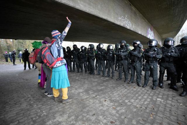 Three demonstrators face a row of police under a bridge during a protest against a two-day convention of far-right Alternative for Germany (AfD) party to establish its new youth organisation in Giessen, western Germany, on November 29, 2025. During the convention, Germany's AfD plans to establish its new youth organisation, to draft the organisation's statutes and elect its new leadership. The AfD's former youth organisation, Junge Alternative (Young Alternative), dissolved in spring 2025 after the party separated from it. Massive counter-protests from politicians and civil society have already been announced. The city announced that it intended to cordon off the entire area around the AfD event venue due to police security concerns. The anti-AfD protests are to be moved to the other side of the Lahn River. (Photo by Sascha Schuermann / AFP)