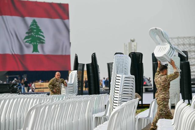 Lebanese soldiers carry plastic chairs as preparations are made on the waterfront in Beirut on November 29, 2025, ahead of Pope Leo XIV's visit to Lebanon. Leo is due to arrive in Lebanon on November 30 for a three-day trip that includes an open-air mass at Beirut's waterfront that organisers expect to draw 120,000 people, as well as an interreligious meeting in the city centre. (Photo by Giuseppe CACACE / AFP)