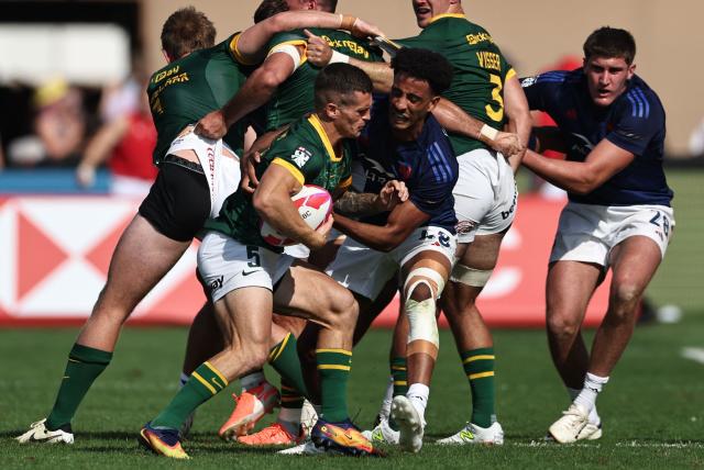 South Africa's #05 Ricardo Duarttee is tackled by France #48 Enahemo Artaud (CR), during the men's Dubai Sevens Rugby Union match between South Africa and France, at the The Sevens Stadium in Dubai on November 29, 2025. (Photo by Fadel SENNA / AFP)