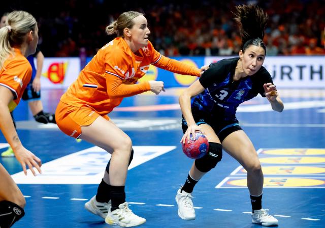 Netherlands' Kelly Dulfer (C) fights for the ball with Argentina's Martina Romero during the Women's Handball World Championship Group E handball match between the Netherlands and Argentina in Rotterdam on November 28, 2025. (Photo by Iris van den Broek / ANP / AFP) / Netherlands OUT