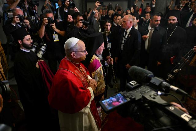 Pope Leo XIV (C-L) and Patriarch Bartholomew I (C) arrive for the doxology at the Patriarchal Church of Saint George, in Istanbul on November 29, 2025. (Photo by Andreas SOLARO / AFP)