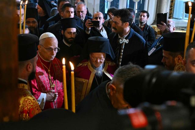 Pope Leo XIV (L) and Patriarch Bartholomew I (C) arrive to take part in a doxology at the Patriarchal Church of Saint George, in Istanbul on November 29, 2025. (Photo by Andreas SOLARO / AFP)