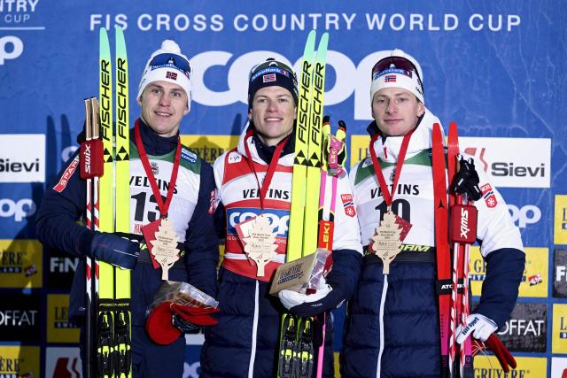 Winner Norway's Johannes Hosflot Klaebo (C) celebrates on the podium with second placed Norway's Erik Valnes (L) and third placed Norway's Ansgar Evensen after the men's cross country classic skiing sprint final at the FIS World Cup Ruka Nordic in Kuusamo, Finland, on November 29, 2025. (Photo by Vesa Moilanen / Lehtikuva / AFP) / Finland OUT