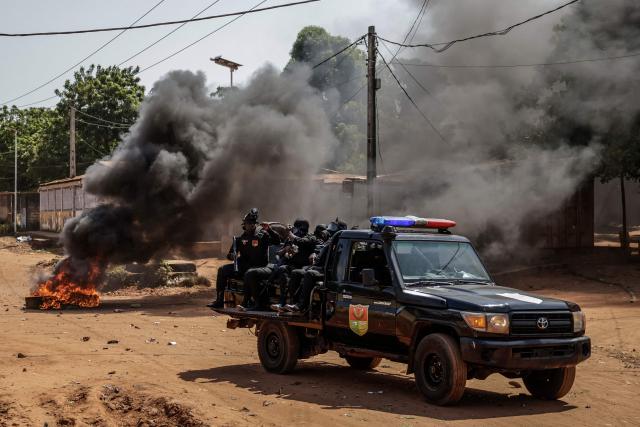 A Guinea Bissau security forces patrol car drives near burning tyres in the area of incidents with protestors in Bissau on Novmeber 29, 2025. (Photo by Patrick MEINHARDT / AFP)