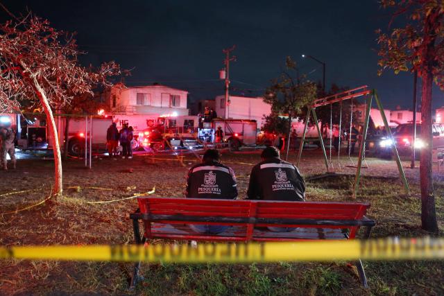 Municipal employees sit outside a house, where clandestine fireworks were manufactured, after it exploded leaving three people dead and six injured, in the municipality of Pesqueria, Nuevo Leon state, Mexico, on November 28, 2025. (Photo by Julio Cesar AGUILAR / AFP)
