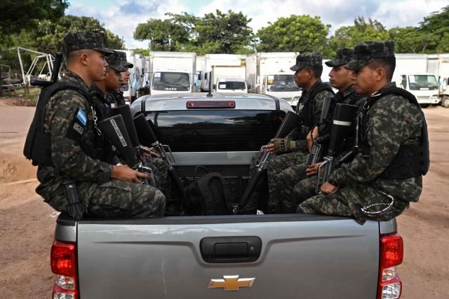 Members of the Armed Forces custody trucks that will transport electoral material at the National Electoral Council logistics centre in Tegucigalpa, on November 29, 2025, a day before the presidential election. (Photo by MARVIN RECINOS / AFP)