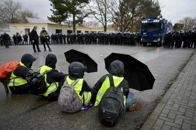 Demonstrators hold up umbrellas while facing police during a protest against a two-day convention of far-right Alternative for Germany (AfD) party to establish its new youth organisation in Giessen, western Germany, on November 29, 2025. (Photo by Sascha Schuermann / AFP)