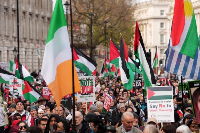 Protesters hold placards and wave Palestinian flags during a march organised by the Palestine Solidarity Campaign in central London on November 29, 2025, calling to "end the occupation, end apartheid and stop arming Israel".  (Photo by CARLOS JASSO / AFP)