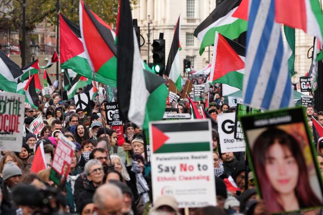 Protesters hold placards and wave Palestinian flags during a march organised by the Palestine Solidarity Campaign in central London on November 29, 2025, calling to "end the occupation, end apartheid and stop arming Israel".  (Photo by CARLOS JASSO / AFP)