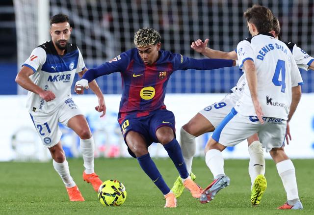Barcelona's Spanish forward #10 Lamine Yamal fights for the ball with Alaves' Algerian forward #21 Abde Rebbach, Alaves' Spanish midfielder #19 Pablo Ibanez and Alaves' Spanish midfielder #04 Denis Suarez during the Spanish League football match between FC Barcelona and Deportivo Alaves at Camp Nou Stadium in Barcelona on November 29, 2025. (Photo by Josep LAGO / AFP)