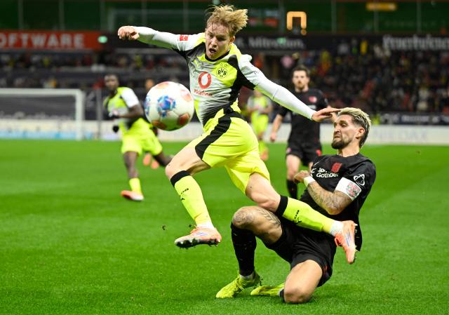 Dortmund's Swedish defender #24 Daniel Svensson (L) and Bayer Leverkusen's German midfielder #08 Robert Andrich vie for the ball during the German first division Bundesliga football match between Bayer 04 Leverkusen and Borussia Dortmund in Leverkusen, western Germany, on November 29, 2025. (Photo by INA FASSBENDER / AFP) / DFL REGULATIONS PROHIBIT ANY USE OF PHOTOGRAPHS AS IMAGE SEQUENCES AND/OR QUASI-VIDEO