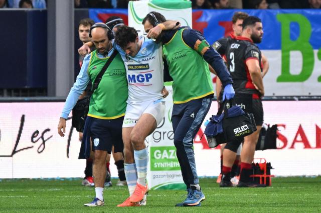 Bayonne's French scrum-half Baptiste Germain (C) leaves the field after beeing injured during the French Top14 rugby union match between Aviron Bayonnais (Bayonne) and Lyon Olympique Universitaire Rugby at Stade Jean Dauger in Bayonne, south-western France on November 29, 2025. (Photo by Gaizka IROZ / AFP)