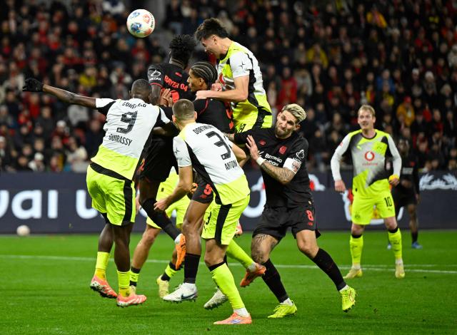 Dortmund's Argentinian defender #28 Aaron Anselmino (Top C) heads the ball to score the 0-1 during the German first division Bundesliga football match between Bayer 04 Leverkusen and Borussia Dortmund in Leverkusen, western Germany, on November 29, 2025. (Photo by INA FASSBENDER / AFP) / DFL REGULATIONS PROHIBIT ANY USE OF PHOTOGRAPHS AS IMAGE SEQUENCES AND/OR QUASI-VIDEO