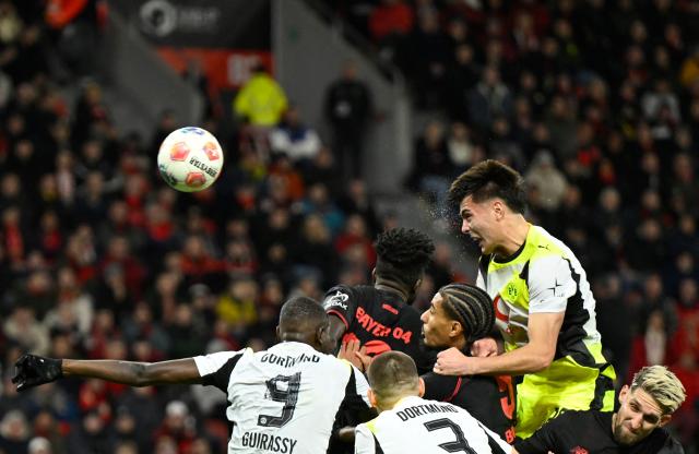 Dortmund's Argentinian defender #28 Aaron Anselmino (Top) heads the ball to score the 0-1 during the German first division Bundesliga football match between Bayer 04 Leverkusen and Borussia Dortmund in Leverkusen, western Germany, on November 29, 2025. (Photo by INA FASSBENDER / AFP) / DFL REGULATIONS PROHIBIT ANY USE OF PHOTOGRAPHS AS IMAGE SEQUENCES AND/OR QUASI-VIDEO