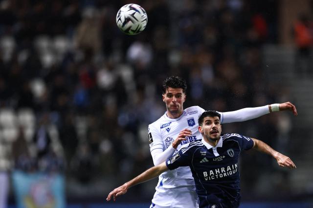 Auxerre's Moroccan midfielder #17 Oussama El Azzouzi fights for the ball with Paris FC's Belgian defender #28 Thibault De Smet during the French L1 football match between Paris FC and AJ Auxerre at the Stade Jean-Bouin stadium, in Paris, on November 29, 2025. (Photo by FRANCK FIFE / AFP)