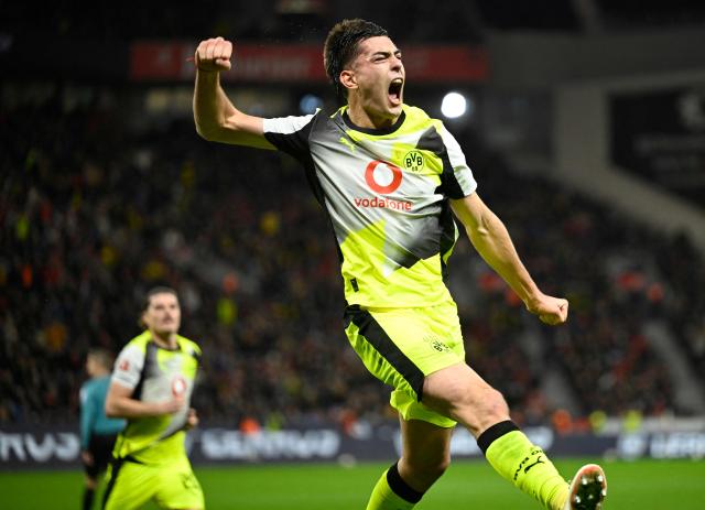 Dortmund's Argentinian defender #28 Aaron Anselmino celebrates his 0-1 during the German first division Bundesliga football match between Bayer 04 Leverkusen and Borussia Dortmund in Leverkusen, western Germany, on November 29, 2025. (Photo by INA FASSBENDER / AFP) / DFL REGULATIONS PROHIBIT ANY USE OF PHOTOGRAPHS AS IMAGE SEQUENCES AND/OR QUASI-VIDEO